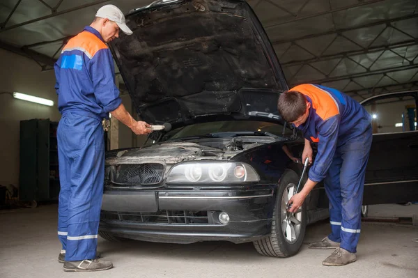 Examining car at the auto repair shop — Stock Photo, Image