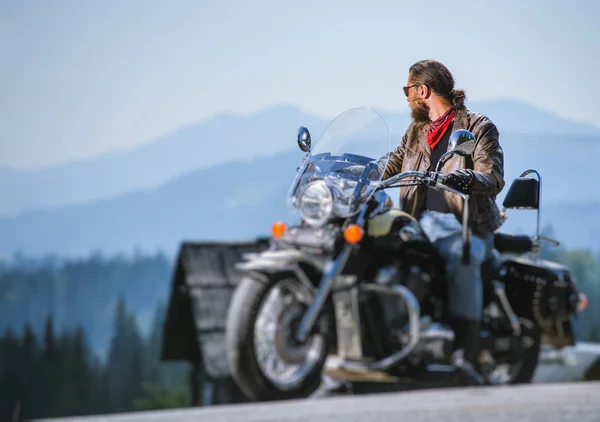 Brutal biker sitting on his motorcycle on a sunny day — Stock Photo, Image