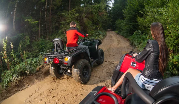 Couple driving four-wheelers ATV offroad — Stock Photo, Image