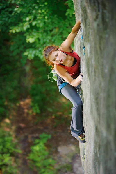 Mulher bonita alpinista escalada rocha íngreme com corda — Fotografia de Stock