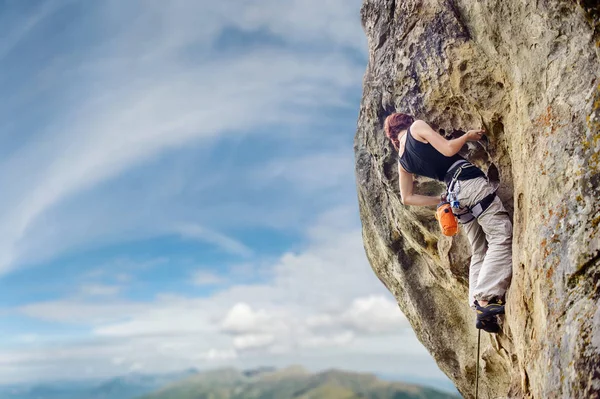 Vrouwelijke rock klimmer op steile overhangende rots rots — Stockfoto