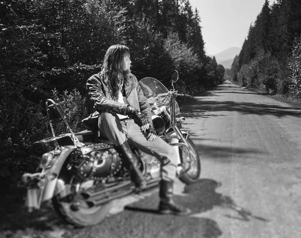 Brutal biker sitting on his motorcycle on a sunny day