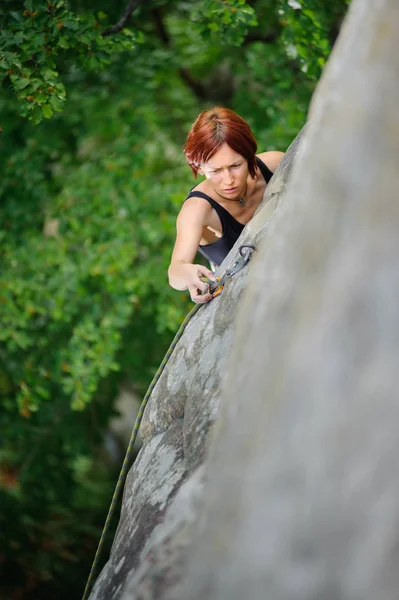 Mujer atlética escalando empinada pared del acantilado en verano — Foto de Stock