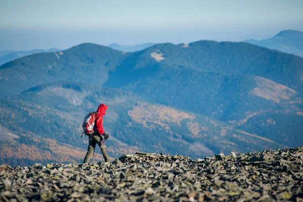 Backpaker masculino andando no topo rochoso da montanha — Fotografia de Stock