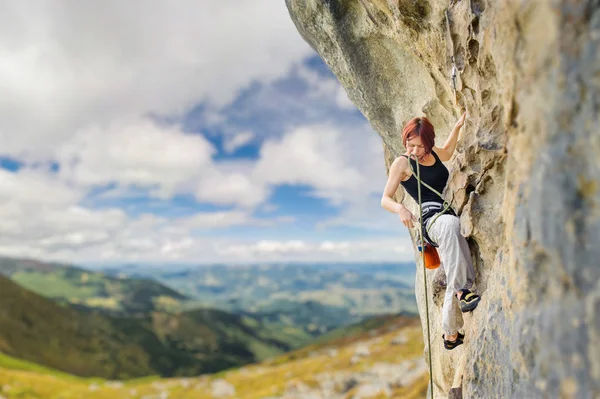 Vrouwelijke rock klimmer op steile overhangende rots rots — Stockfoto