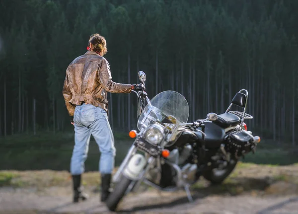 Biker standing by his custom made cruiser motorcycle — Stock Photo, Image