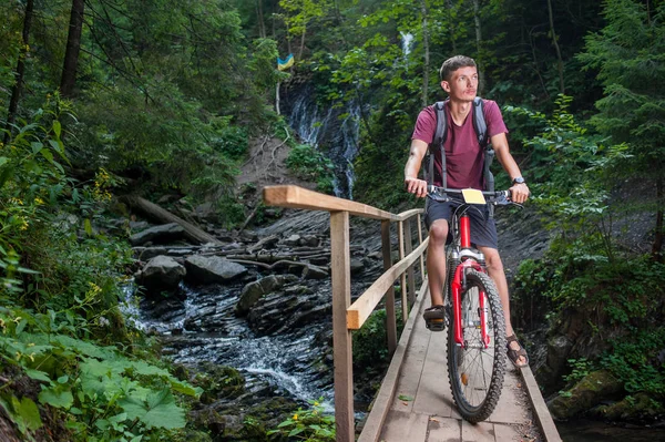 Giovane uomo in bicicletta nella foresta — Foto Stock