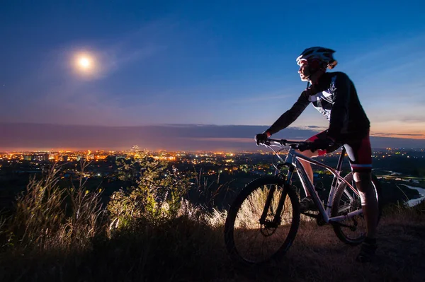 Велогонщик с горным велосипедом на вершине холма — стоковое фото