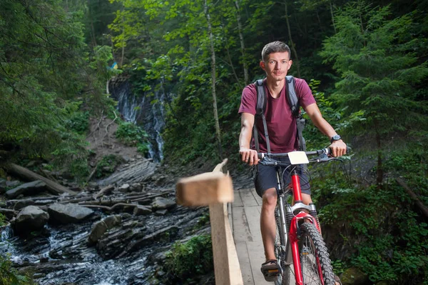 Giovane uomo in bicicletta nella foresta — Foto Stock