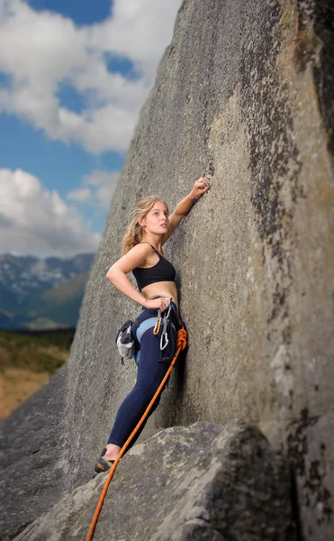 Žena horolezec lezení s lanem na skalní stěně — Stock fotografie