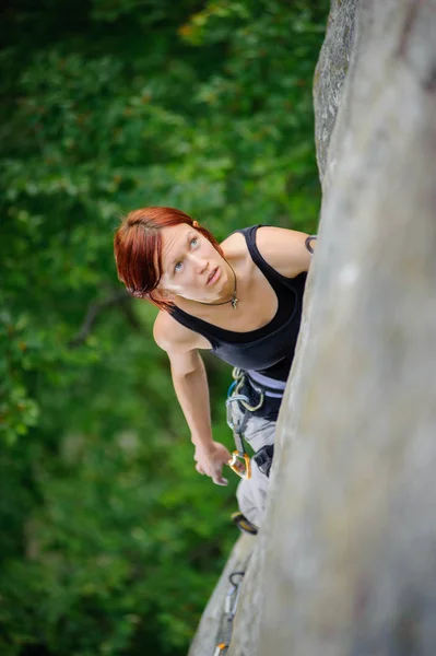 Athletic woman climbing steep cliff wall in summer time — Stock Photo, Image