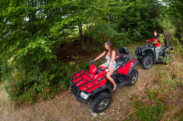 Happy couple driving four-wheelers ATV