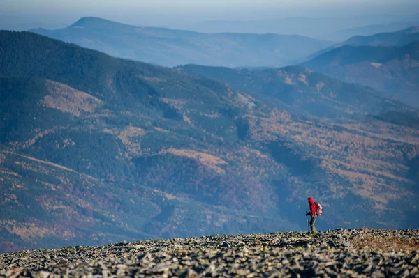 Backpaker masculino andando no topo rochoso da montanha — Fotografia de Stock