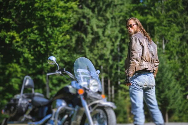 Biker standing by his custom made cruiser motorcycle — Stock Photo, Image