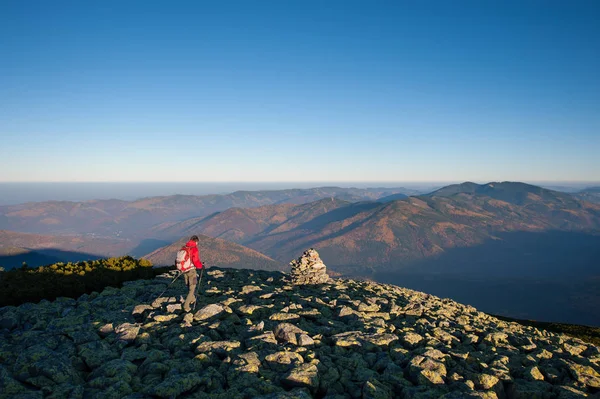 Backpaker masculino caminando en la cima rocosa de la montaña — Foto de Stock