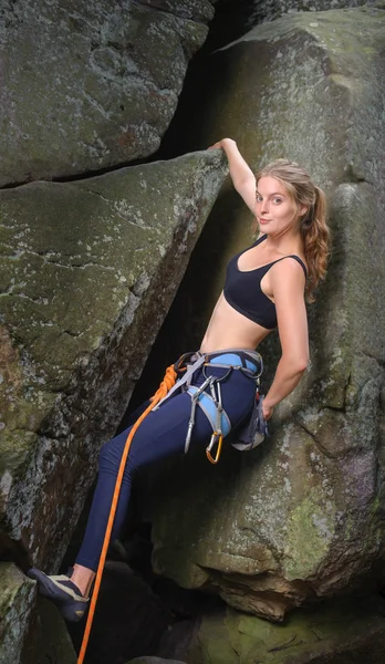 Mulher alpinista escalada com corda em uma parede rochosa — Fotografia de Stock