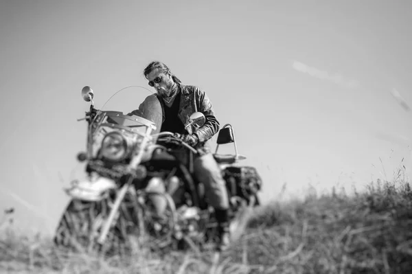 Βάναυση ποδηλάτης καθισμένος στη μοτοσικλέτα του σε μια ηλιόλουστη ημέρα — Φωτογραφία Αρχείου