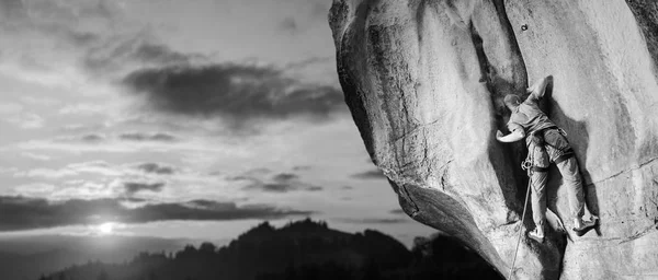 男登山者攀登大石头用绳子的性质 — 图库照片
