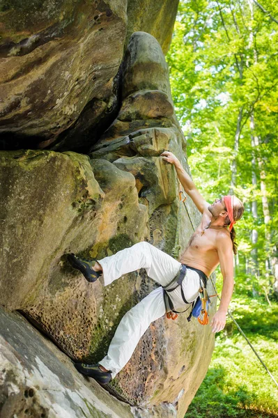 Αρσενικό ροκ ορειβάτης αναρρίχηση με σχοινί σε έναν βραχώδη τοίχο — Φωτογραφία Αρχείου