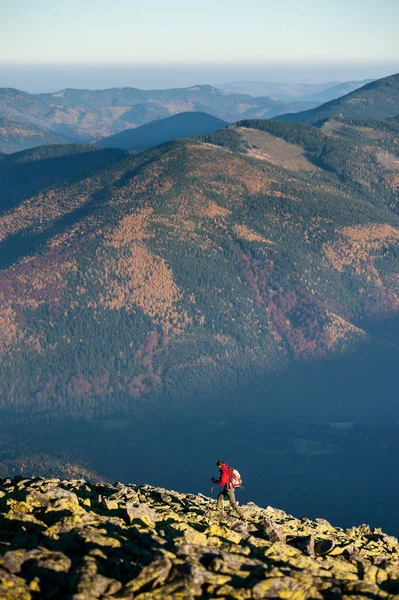 Backpaker mâle marchant sur le sommet rocheux de la montagne — Photo