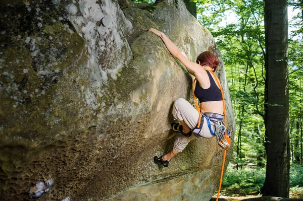 岩の壁にロープで登る女性登山家 — ストック写真