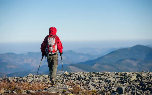 Backpaker masculino andando no topo rochoso da montanha — Fotografia de Stock