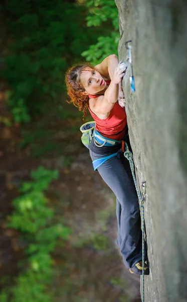 Красива жінка скелелазіння крутий камінь з мотузкою — стокове фото