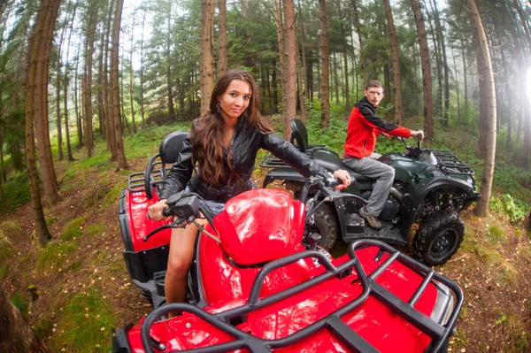 Happy beautiful couple driving four-wheelers ATV — Stock Photo, Image