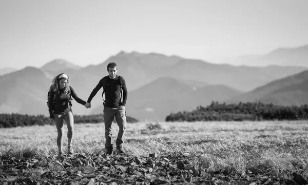 Caminhadas de casal nas belas montanhas no dia ensolarado quente — Fotografia de Stock