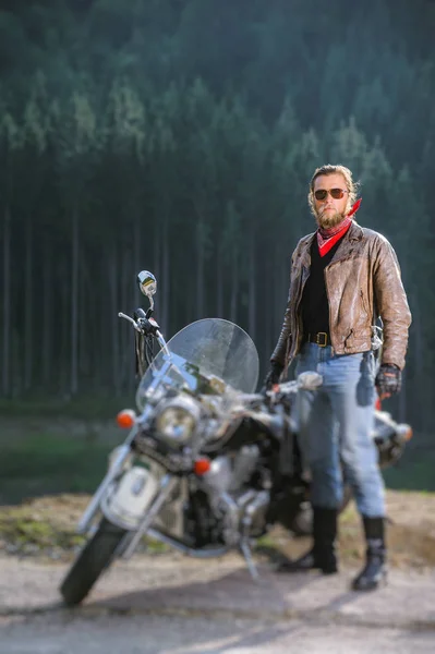 Biker standing by his custom made cruiser motorcycle — Stock Photo, Image