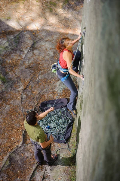 美しい女性クライマーがロープで急な岩を登る — ストック写真
