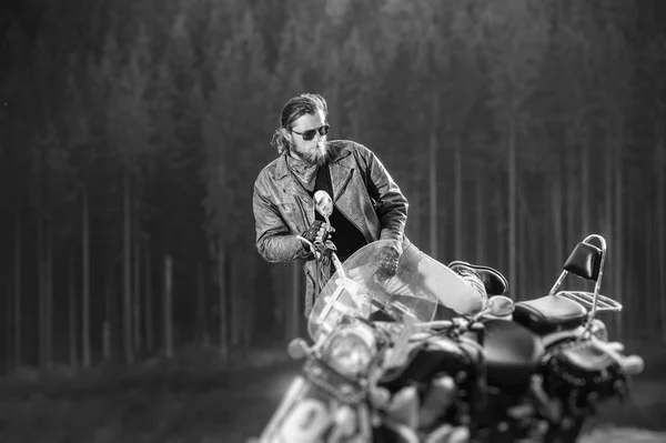 Handsome biker standing by his custom made cruiser motorcycle — Stock Photo, Image