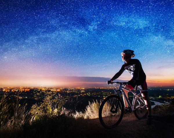 Bicyclist with mountain bike on top of the hill