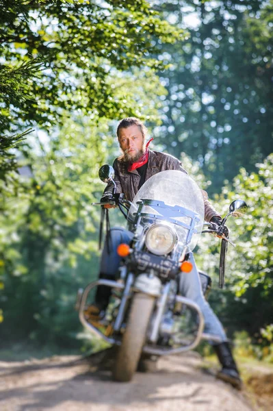 Ποδηλάτης οδηγώντας μοτοσικλέτα καταδρομικό του στον δρόμο μέσα στο δάσος — Φωτογραφία Αρχείου