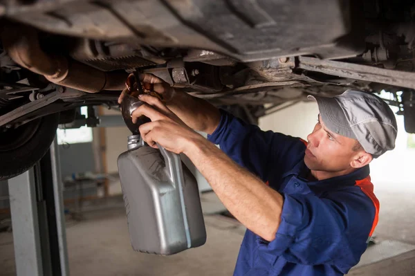 Portrait of car mechanic working with tools under car — Stock Photo, Image