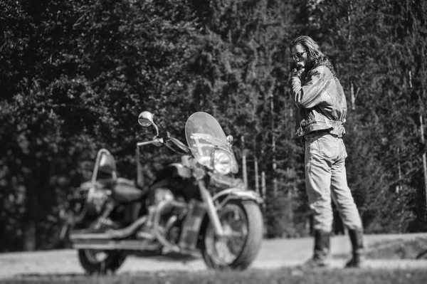 Handsome biker standing by his custom made cruiser motorcycle — Stock Photo, Image