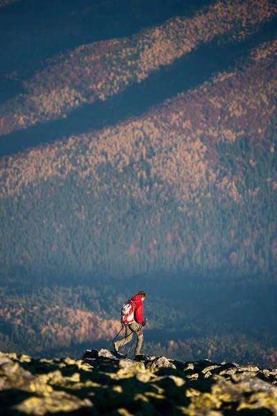 Backpaker masculino andando no topo rochoso da montanha — Fotografia de Stock