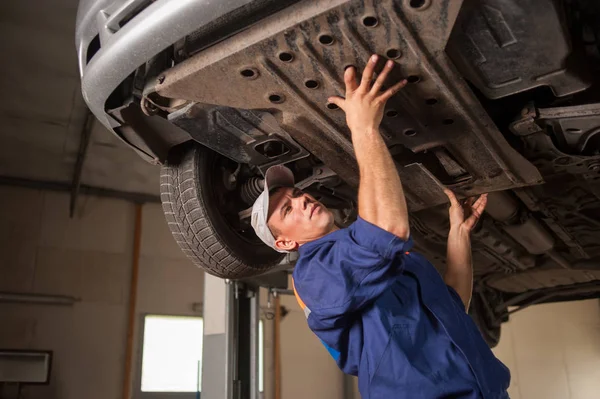 Retrato del mecánico del coche que trabaja con las herramientas debajo del coche —  Fotos de Stock