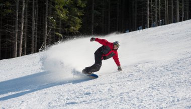Erkek snowboard dağdan aşağı kayıyor