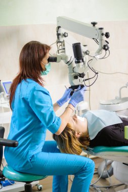 Mikroskopla modern dişçi klinikte çalışan kadın diş hekimi