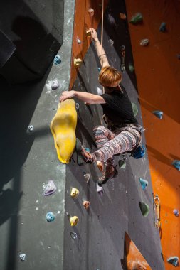 Kadın dağcı kapalı dağ tırmanışı duvara tırmanıyor