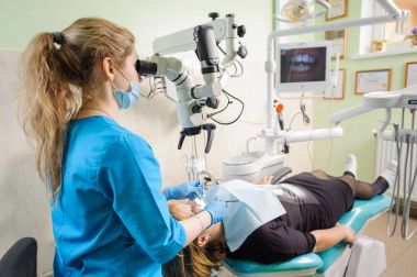 Mikroskopla modern dişçi klinikte çalışan kadın diş hekimi