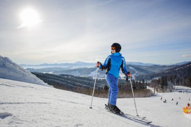 Genç güzel kadın kayakçı Kayak pistinin ortasında
