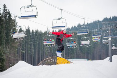 Kış günü bir engel uçan snowboarder