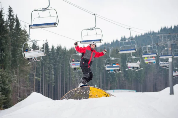Snowboarder πετούν πάνω από ένα εμπόδιο σε μέρα του χειμώνα — Φωτογραφία Αρχείου