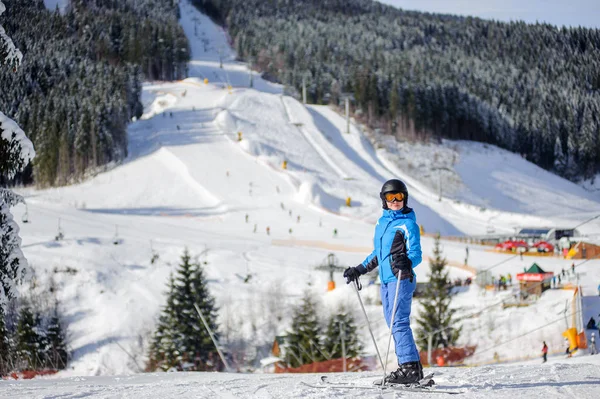 Esquiadora en una pista de esquí en un día soleado —  Fotos de Stock