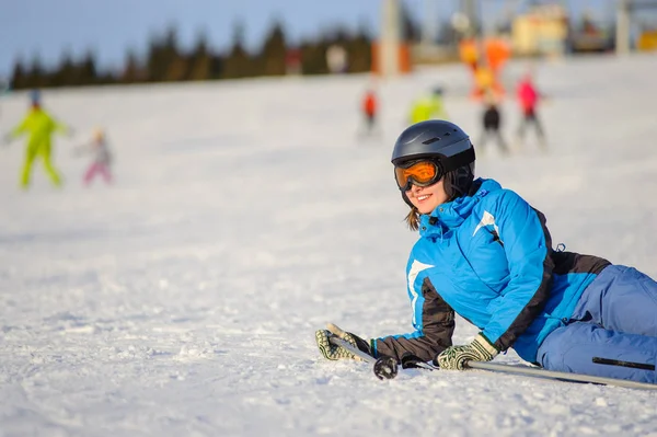 Ung kvinna skidåkare efter nedgången på bergssluttning — Stockfoto