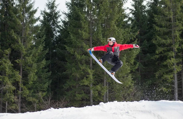 Boarder auf dem Snowboard springt über die Piste — Stockfoto