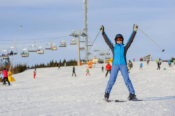 Kvinna skidåkare skidåkning nedför vid skidorten mot skidlift — Stockfoto