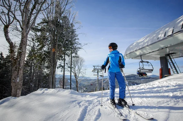 Feminino esquiador contra ski-lift e inverno montanhas fundo — Fotografia de Stock